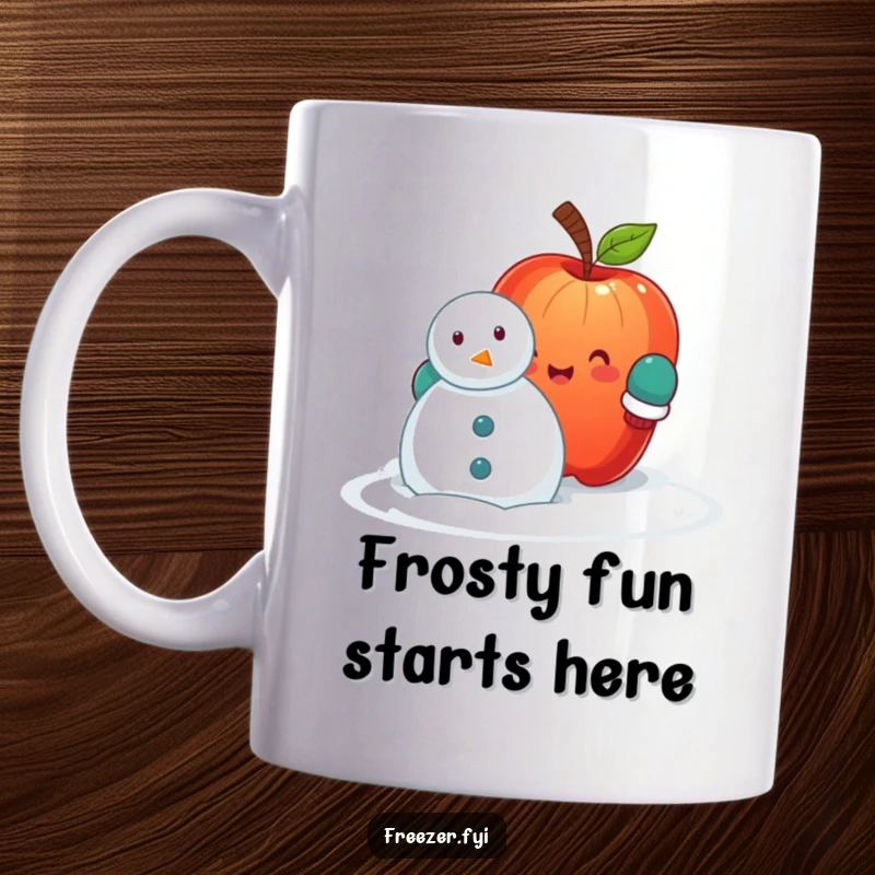 Funny mug featuring a cheerful apple wearing mittens, struggling to build a small snowman, radiating winter joy and playful effort.