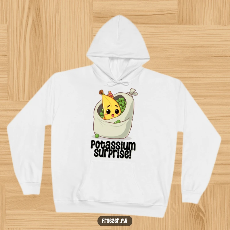 Funny hoodie with a surprised banana in a tiny hat, peeking from behind a giant bag of peas, warm and humorous.